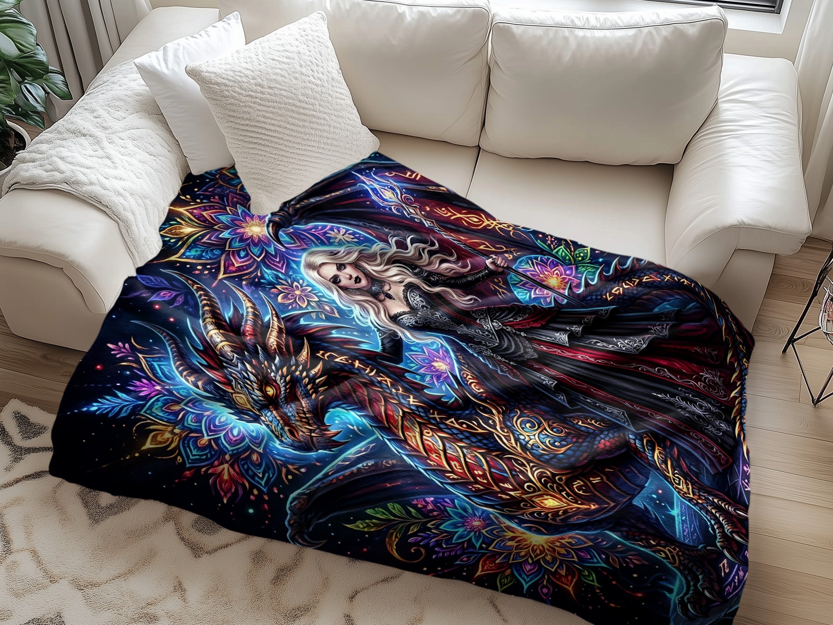 Fantasy blanket with blonde woman and dragon design on white sofa.
